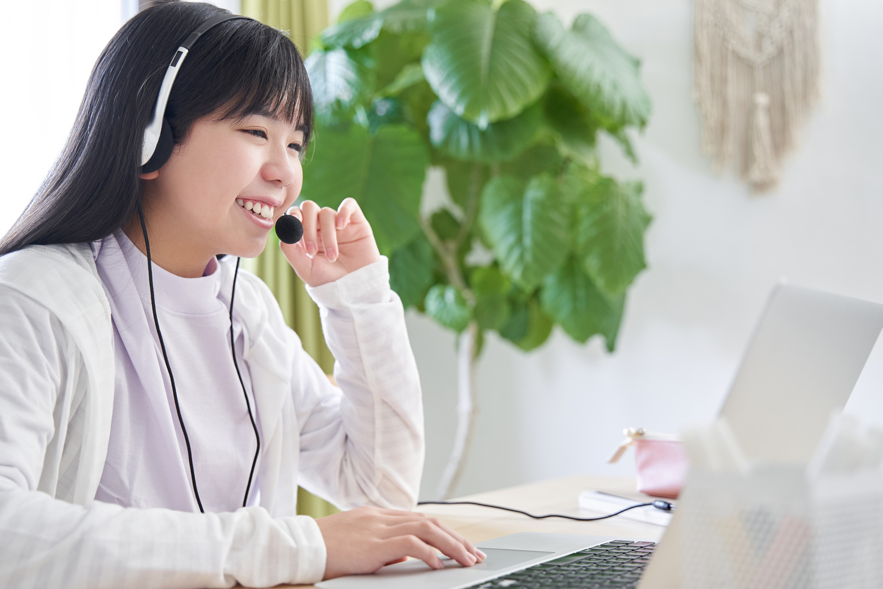 A Japanese junior high school girl attending an online lecture in her living room